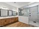 Luxurious main bathroom with dual sink vanity, wood cabinets, and a glass-enclosed shower at 3366 E Constance Way, Phoenix, AZ 85042