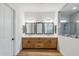 Bright main bathroom features a double sink vanity with wood cabinets and a large glass shower at 3366 E Constance Way, Phoenix, AZ 85042