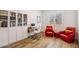 Home office featuring wood floors, built in bookcases, work station and two red accent chairs at 3366 E Constance Way, Phoenix, AZ 85042