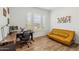 Bright home office features wood floors, large window with shutters and stylish yellow couch at 3366 E Constance Way, Phoenix, AZ 85042
