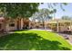 Expansive backyard with a lush lawn, mature trees, an outdoor bar, and a sparkling pool at 3522 E Cherokee St, Phoenix, AZ 85044