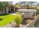 Spacious backyard with lush lawn, outdoor kitchen, mature trees, and sparkling pool, perfect for outdoor living at 3522 E Cherokee St, Phoenix, AZ 85044