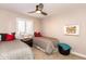 Comfortable bedroom featuring twin beds, soft lighting, and a ceiling fan at 3522 E Cherokee St, Phoenix, AZ 85044