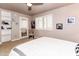 Bright bedroom with white bedding, large windows, and a ceiling fan at 3522 E Cherokee St, Phoenix, AZ 85044