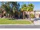 Exterior view of a single Gathering home, featuring a green lawn, palm trees, and a stone facade at 3522 E Cherokee St, Phoenix, AZ 85044
