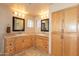 Bathroom with dual sinks, wooden cabinetry, mirrors and glass block windows for natural light at 3522 E Cherokee St, Phoenix, AZ 85044