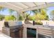Outdoor kitchen area with a built-in grill, mini fridge, and sink, perfect for backyard barbecues at 3522 E Cherokee St, Phoenix, AZ 85044