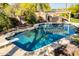 Backyard oasis with a sparkling pool featuring a diving board, lush desert landscaping, and an outdoor bar at 3522 E Cherokee St, Phoenix, AZ 85044