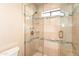 Tiled shower with glass door enclosure, shelving, and chrome shower head at 3522 E Cherokee St, Phoenix, AZ 85044