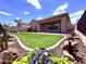 Lush backyard featuring a well-manicured artificial lawn, desert landscaping, and a covered patio with ample space at 3780 E Rakestraw Ln, Gilbert, AZ 85298