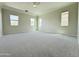 Spacious bedroom with neutral carpet, ceiling fan, and multiple windows for ample light at 3780 E Rakestraw Ln, Gilbert, AZ 85298