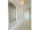 Bright hallway with white trim, tiled flooring, storage closets, and decorative lighting, leading to the main rooms at 3780 E Rakestraw Ln, Gilbert, AZ 85298