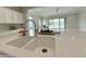 Bright kitchen with a modern faucet, a white countertop, and a seamless flow into the living area at 3780 E Rakestraw Ln, Gilbert, AZ 85298