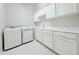 Bright laundry room with white cabinets, sink, countertop, and modern washer and dryer at 3780 E Rakestraw Ln, Gilbert, AZ 85298