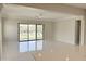 Bright living room with sleek white tile floors and a large glass sliding door for indoor-outdoor living at 3780 E Rakestraw Ln, Gilbert, AZ 85298