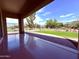 Covered patio with smooth flooring, a glimpse of a manicured backyard, desert landscaping, and secure fencing at 3780 E Rakestraw Ln, Gilbert, AZ 85298