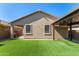 This backyard features artificial grass and two patios at 44837 W Horse Mesa Rd, Maricopa, AZ 85139
