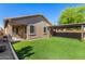 This backyard features a covered patio and artificial grass at 44837 W Horse Mesa Rd, Maricopa, AZ 85139
