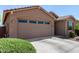 Attached two-car garage with automatic door and driveway, complemented by fresh, well-maintained landscaping at 44837 W Horse Mesa Rd, Maricopa, AZ 85139