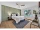 Cozy bedroom with stylish accent wall, ceiling fan, and a large window for natural light at 5008 W New World Dr, Glendale, AZ 85302