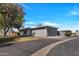 A gray single-Gathering home with a well-manicured lawn and a long driveway leading to an attached garage at 5008 W New World Dr, Glendale, AZ 85302