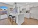 Contemporary kitchen featuring a waterfall island, stainless steel appliances, and sliding glass doors to patio at 5008 W New World Dr, Glendale, AZ 85302