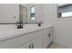 Bathroom features a dual sink vanity with white cabinets, black hardware, and modern fixtures at 537 E Aurora Dr, San Tan Valley, AZ 85140