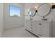 Bright bathroom features a double vanity with modern fixtures and stylish round mirrors at 537 E Aurora Dr, San Tan Valley, AZ 85140