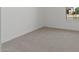 This carpeted bedroom has a neutral color palette and natural light streaming from a window at 537 E Aurora Dr, San Tan Valley, AZ 85140
