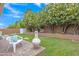 Lush backyard featuring a lawn, mature landscaping, a paved seating area and privacy fencing at 616 E Sheffield Ave, Gilbert, AZ 85296