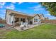 Home's backyard features a covered patio, barbecue grill, lawn area, landscaping and privacy fence at 616 E Sheffield Ave, Gilbert, AZ 85296