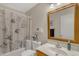 Well-lit bathroom with a large framed mirror, printed shower curtain and vanity at 616 E Sheffield Ave, Gilbert, AZ 85296