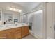 Bathroom featuring double sinks, wooden cabinets, and a glass-enclosed shower for a modern feel at 616 E Sheffield Ave, Gilbert, AZ 85296