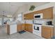 Well-lit kitchen featuring tile floors, oak cabinets, white appliances, and a convenient layout at 616 E Sheffield Ave, Gilbert, AZ 85296