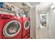 Conveniently placed, updated laundry room with red washer and dryer sits adjacent to hallway at 6226 N 21St Dr, Phoenix, AZ 85015