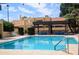 Sparkling pool with blue picnic tables and lounge chairs under a shaded pergola at this community property at 6226 N 21St Dr, Phoenix, AZ 85015