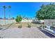 Inviting backyard featuring a stone path, gravel ground cover, swing, and views of lush trees and palms at 635 W Gable Ave, Mesa, AZ 85210