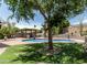 Large backyard with mature trees, a sparkling pool, and an outdoor kitchen at 6422 W Range Mule Dr, Phoenix, AZ 85083
