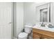 Well-lit half bathroom with vanity, toilet, and decorative mirror at 6422 W Range Mule Dr, Phoenix, AZ 85083