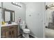 Bright bathroom featuring a wood vanity, toilet, decorative mirror, and colorful accents at 6422 W Range Mule Dr, Phoenix, AZ 85083