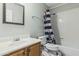 Bathroom featuring a wood vanity, and a shower/tub with blue-striped shower curtain at 6422 W Range Mule Dr, Phoenix, AZ 85083