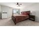 Cozy bedroom with neutral carpet, ceiling fan, and ample natural light from the windows at 6422 W Range Mule Dr, Phoenix, AZ 85083