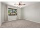 Bedroom featuring neutral walls, carpet, ceiling fan, and a bright window at 6422 W Range Mule Dr, Phoenix, AZ 85083