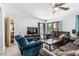 Cozy living room with plush seating, a ceiling fan, and large windows at 6422 W Range Mule Dr, Phoenix, AZ 85083