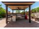 Outdoor kitchen with built in grill, bar seating and overhead fan at 6422 W Range Mule Dr, Phoenix, AZ 85083
