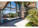 A modern building exterior features walls of glass and open terraces with lush, tropical landscaping at 7167 E Rancho Vista Dr # 4010, Scottsdale, AZ 85251
