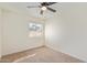 A simple bedroom with a ceiling fan, a window bringing in natural light and carpeted floors at 7464 N 43Rd Ave, Glendale, AZ 85301