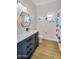 Bright bathroom with wood floors, navy vanity, and colorful shower curtain at 824 W Mesquite St, Gilbert, AZ 85233