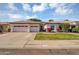 Charming single-story home featuring lush green lawn, desert landscaping, and a two-car garage at 824 W Mesquite St, Gilbert, AZ 85233