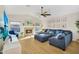 Comfortable living room with a fireplace, large TV, blue sectional, and ceiling fan at 824 W Mesquite St, Gilbert, AZ 85233